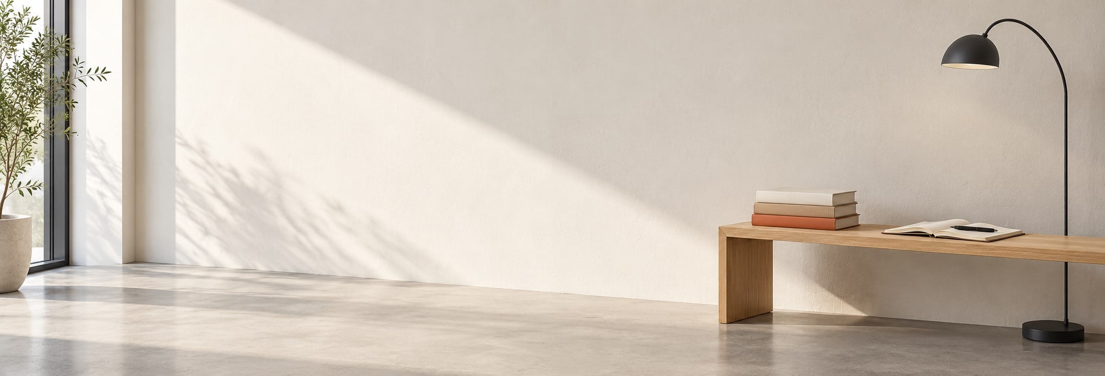 A sunlit minimalist reading nook with books and an open notebook on an oak bench
