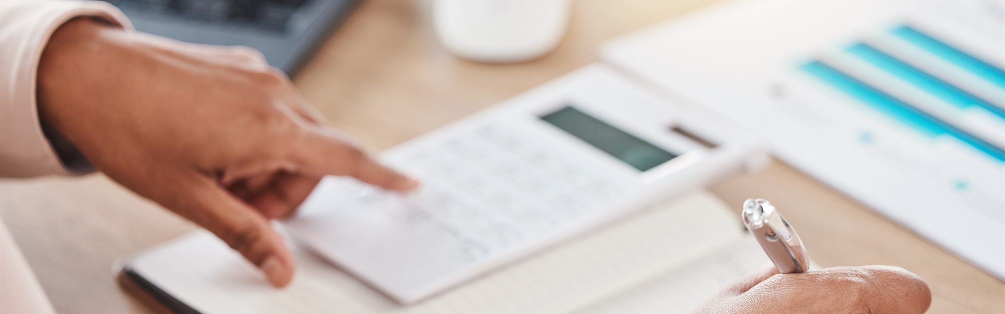 A person working out loan numbers with a calculator at a desk