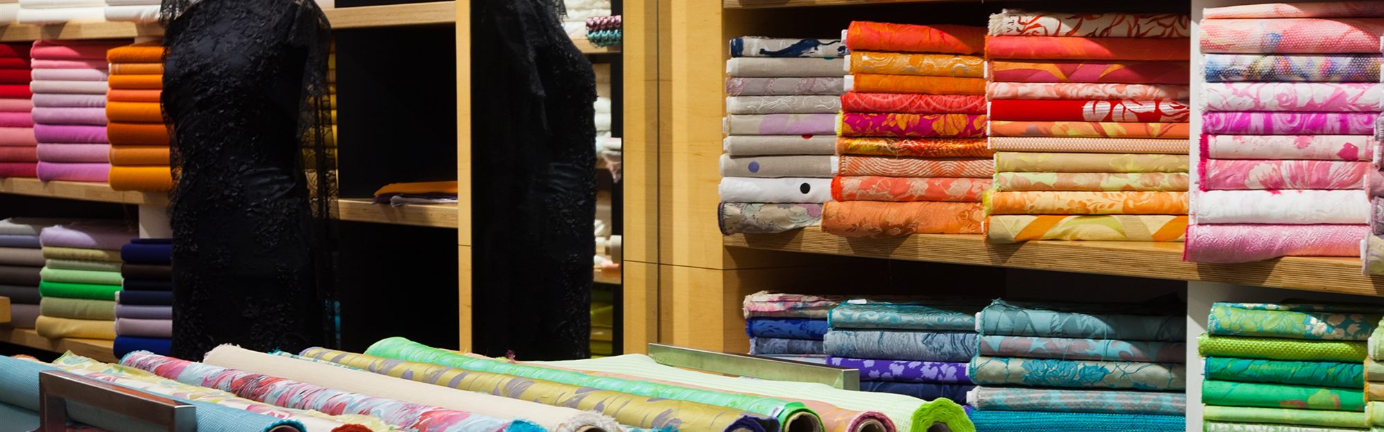 Rolls of colourful fabric on display in an Indian textile shop