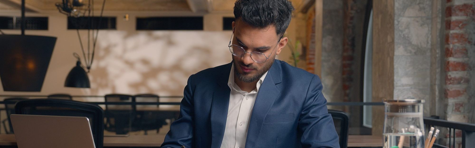 A business owner reviewing and signing loan documents at a desk